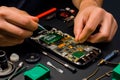 Repairman uses tweezers to repair damaged smartphone. Generative AI