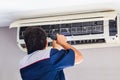 Repairman using a screwdriver fixing modern air conditioner, Male technician cleaning air conditioner indoors, Maintenance and Royalty Free Stock Photo