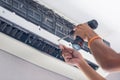 Repairman using a screwdriver fixing modern air conditioner, Male technician cleaning air conditioner indoors, Maintenance and Royalty Free Stock Photo