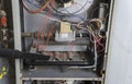 Repairman Vacuuming Inside Of Furnace