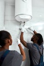 Repairman in white gloves installing electric boiler Royalty Free Stock Photo