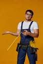 Repairman worker in uniform holding measure tape. Royalty Free Stock Photo