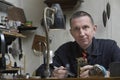 Repairman Working On Clock In Workshop