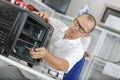 Repairman working on microwave in kitchen Royalty Free Stock Photo