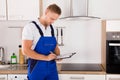 Repairman Writing On Clipboard Royalty Free Stock Photo