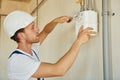 Repaiting the pipes. Young man working in uniform at construction at daytime Royalty Free Stock Photo