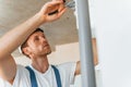 Repaiting the pipes. Young man working in uniform at construction at daytime Royalty Free Stock Photo