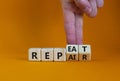 Repeat and repair symbol. Businessman turns wooden cubes and changes the word `repeat` to `repair`. Beautiful orange table, or