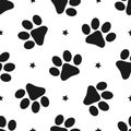 Repeated silhouettes of paw prints and stars. Seamless pattern for animals. Royalty Free Stock Photo