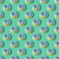 A repeating pattern of blue donuts with a rainbow on a green background. Flat lay Royalty Free Stock Photo