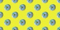 A repeating pattern of blue donuts with a rainbow on a yellow background. Flat lay Royalty Free Stock Photo