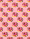 Repeating pattern of pink donuts on a pink background. Flat lay Royalty Free Stock Photo