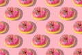 Repeating pattern of pink donuts on a pink background. Flat lay Royalty Free Stock Photo