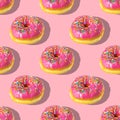 Repeating pattern of pink donuts on a pink background. Flat lay Royalty Free Stock Photo