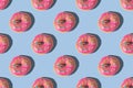Repeating pattern of pink donuts on a blue background. Flat lay Royalty Free Stock Photo