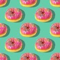 Repeating pattern of pink donuts on a green background. Flat lay Royalty Free Stock Photo