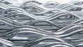 Repeating pattern of shiny metallic silver wavy lines creating a textured and reflective abstract background Royalty Free Stock Photo