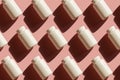 Repeating white cans of pills on a pink background