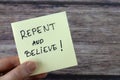 Repent and believe, handwritten message on a note in hand