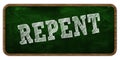 REPENT written with chalk on green chalkboard. Wooden frame.