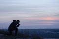 Repentance. A man on his knees. Prayer. Silhouette of a man on a blue sky background. Kneeling Prayer to God. Glorification