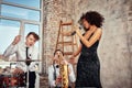 Repetition of multi ethnic jazz band in loft. Female African solist, saxophonist and drummer at loft. Jazz music and jam Royalty Free Stock Photo