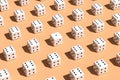 Repetitive white dices pattern in a row on pink beige background Royalty Free Stock Photo