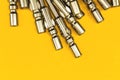 Replaceable bits close-up view, a pile of metal screwdriver bits on a yellow background Royalty Free Stock Photo