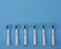 Replaceable nozzles for electric toothbrush of different colors on on blue background with copy space. Flat lay Royalty Free Stock Photo