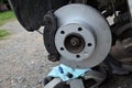 Replacement of the brake disc at the car in domestic conditions. the car repairman removes the worn brakes and puts on new ones. h Royalty Free Stock Photo