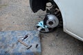 Replacement of the brake disc at the car in domestic conditions. the car repairman removes the worn brakes and puts on new ones. h Royalty Free Stock Photo