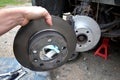 Replacement of the brake disc at the car in domestic conditions. the car repairman removes the worn brakes and puts on new ones. h Royalty Free Stock Photo