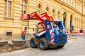 Replacement of curbs and repair of sidewalks in the old city. Workers change the curb with the help of a tractor