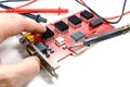Replacement of electronic component on the DVR motherboard with a soldering iron on a white background Royalty Free Stock Photo