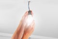 Replacing an glowing electrical energy saving white light bulb. Conceptual view Royalty Free Stock Photo