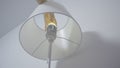 Replacing light bulb in floor lamp. Action. Hand screws new light bulb into floor lamp with different colors. Light bulb