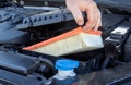 Replacing an old dirty air filter in the engine compartment of a car engine. The mechanic is servicing the car. Cleaning Royalty Free Stock Photo