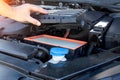 Replacing an old dirty air filter in the engine compartment of a car engine. The mechanic is servicing the car. Cleaning Royalty Free Stock Photo