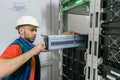 . Replacing the power module in the server room rack. Maintenance of data center equipment. The technician installs a new battery