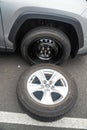 Replacing a punctured wheel with a temporary car wheel on the road