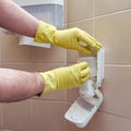 Replacing soap in a dispenser on the wall of a public toilet Royalty Free Stock Photo