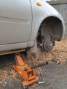 replacing a wheel on a car, the car is lifted on a jack with the front wheel removed