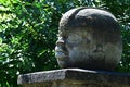 Replica of Olmec round stone head statue on pedestal