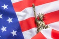 A replica of the Statue of liberty placed on the USA flag. There is Lighting on the side of the statue. 4th of July, Celebrate Royalty Free Stock Photo