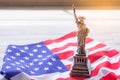 A replica of the Statue of liberty placed on the USA flag. There is Lighting on the side of the statue. 4th of July, Celebrate Royalty Free Stock Photo