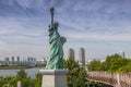 Replicas of the Statue of Liberty with cityscape background at Odaiba Park in Tokyo, Japan