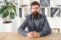 Report and complaint concept. Man bearded hipster boss looking at you with attention. Boss sit in office. Boss receive Royalty Free Stock Photo