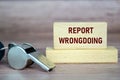 Report Wrongdoing text on wooden blocks with whistle. Whistleblow concept Royalty Free Stock Photo