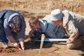 A reporter and cameraman filming a report on archaeological excavations