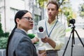 reporter holding microphone near distracted asian